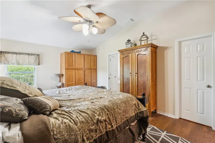 Bedroom with lofted ceiling, ceiling fan, and dark hardwood / wood-style flooring