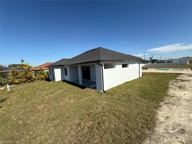Rear view of property with a lawn