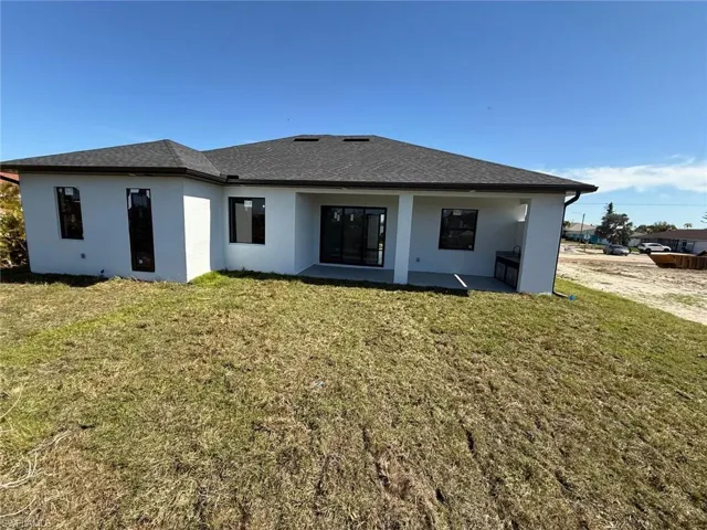 Rear view of property featuring a yard and a patio
