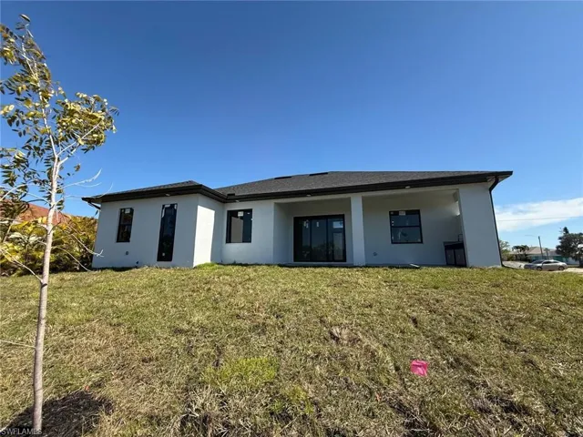 Back of house with a lawn