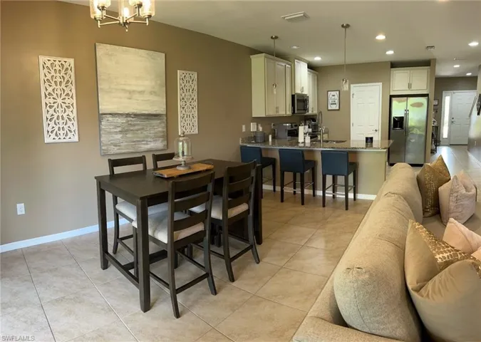 Dining room with sink, light tile patterned flooring, and a chandelier