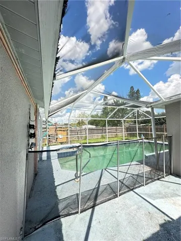 View of swimming pool featuring glass enclosure, a patio area, a sunroom, and a fenced backyard