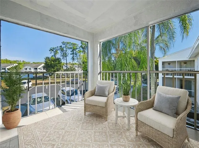 Screened balcony featuring a textured ceiling, a textured floor, and metal railings