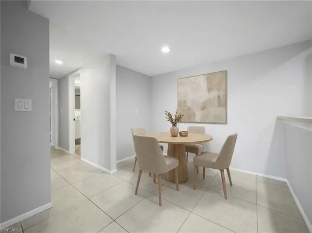 Bright dining area featuring recessed lighting, light-toned tile flooring, and a neutral color palette