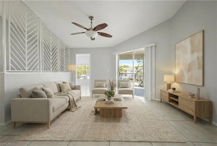 Vaulted ceiling with a ceiling fan, sliding glass door, and a decorative interior half-wall with a geometric pattern