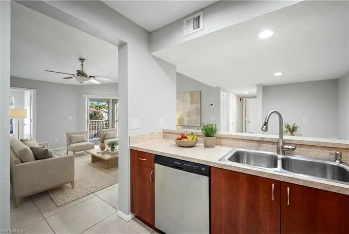 Kitchen featuring a double stainless steel sink, pull-down faucet, integrated dishwasher, and wood cabinetry