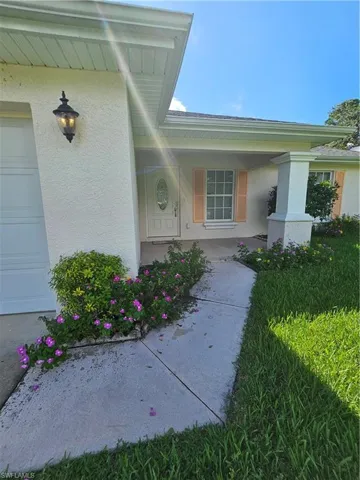 Property entrance with covered porch and a garage