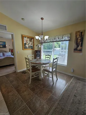 Dining space with vaulted ceiling and a chandelier