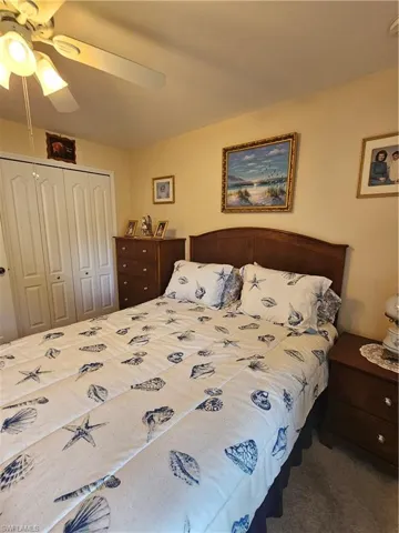 Bedroom featuring a closet, dark colored carpet, and ceiling fan