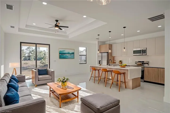 Living room with ceiling fan, recessed lighting, and finished concrete floors