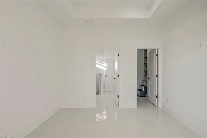 Unfurnished room with a raised ceiling and light tile patterned floors