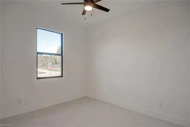 Empty room featuring baseboards and a ceiling fan