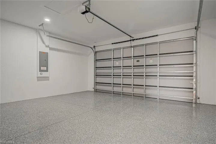 Garage featuring electric panel and a garage door opener