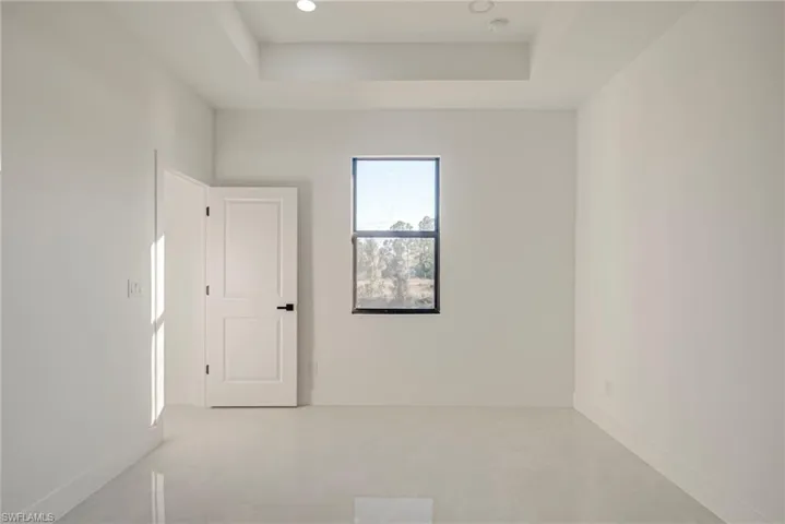 Spare room featuring a raised ceiling and recessed lighting