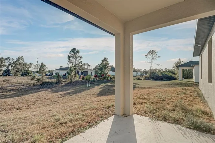 View of grassy yard with a patio and a residential view