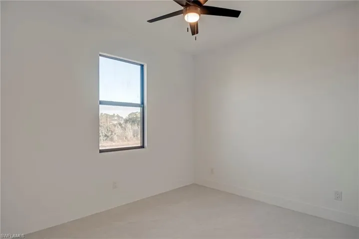 Spare room with baseboards and a ceiling fan