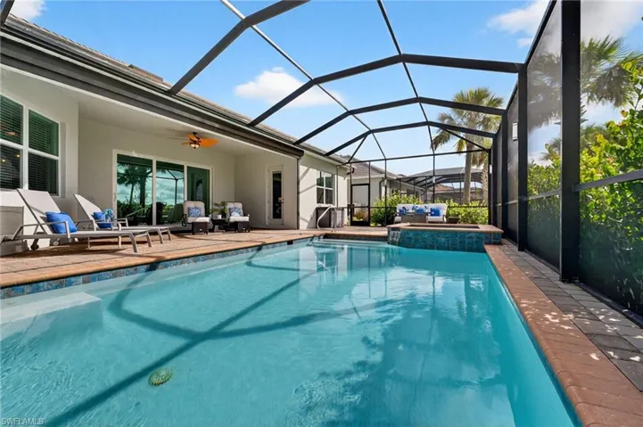 Outdoor pool with a sunroom, a patio, ceiling fan, an outdoor hangout area, and glass enclosure