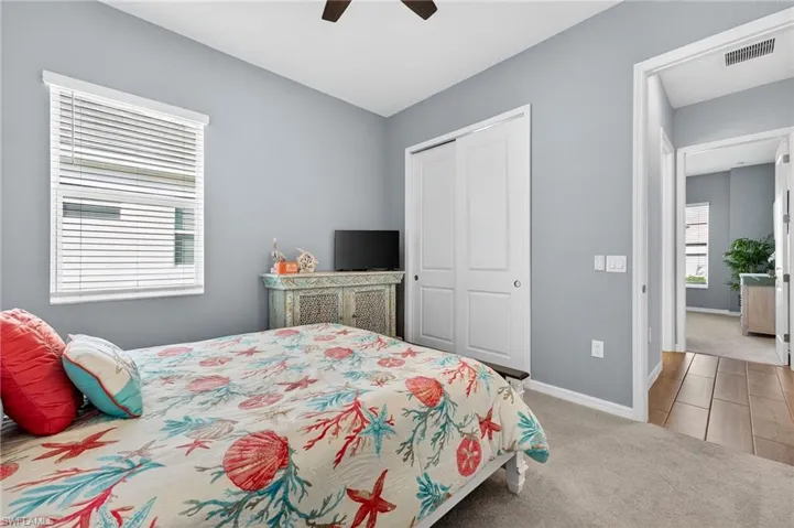 Bedroom with light carpet, a closet, and ceiling fan