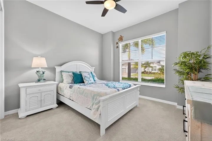 Bedroom with light carpet and a ceiling fan