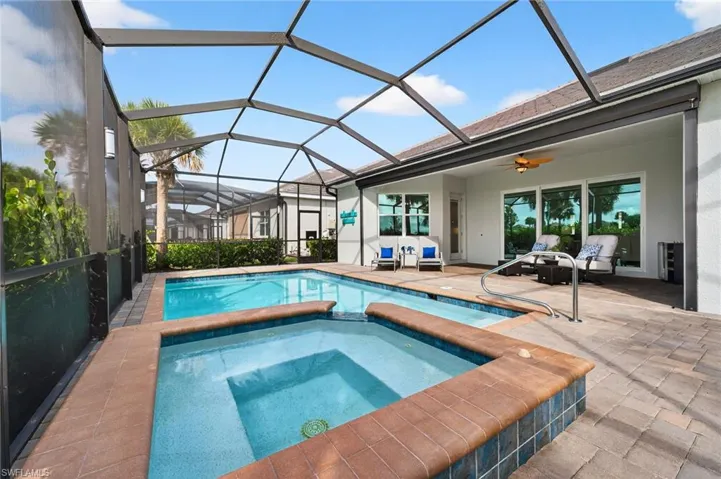 View of pool featuring a patio area, a sunroom, ceiling fan, and glass enclosure