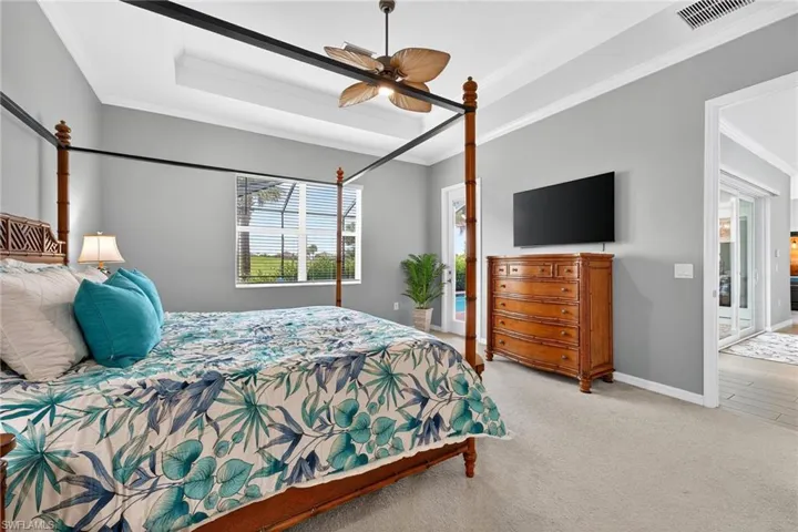 Bedroom featuring ornamental molding, carpet flooring, access to exterior, and a ceiling fan