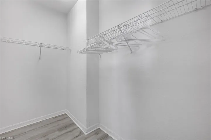 Walk in closet with wood-type flooring