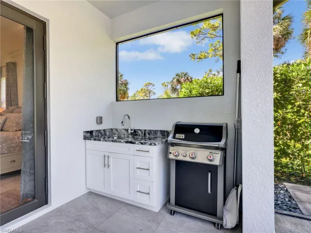 Under Cover Wet Bar With White Shaker Cabinetry, Quartz Counter & Stainless-Steel Sink