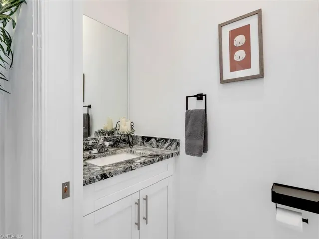 Powder Bathroom With White Shaker Cabinetry and Quartz Counter