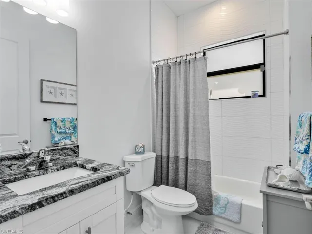 Full Bathroom With Floor To Ceiling Tiled Shower, and White Shaker Vanity With Quartz Counter
