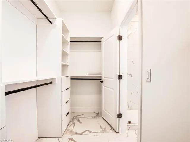 Spacious closet with light marble style finish flooring