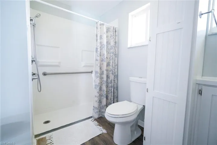 Full bathroom featuring wood finished floors and a shower with shower curtain