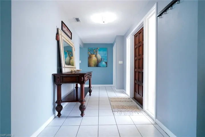 Corridor featuring light tile patterned flooring and baseboards