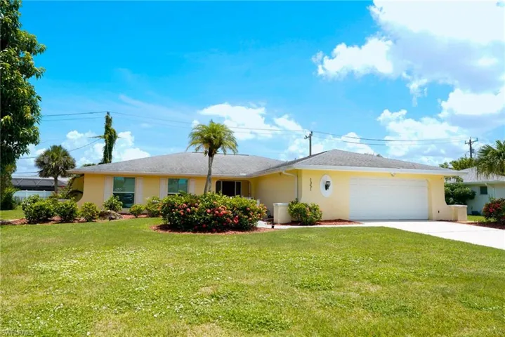 Ranch-style house with a garage, driveway, a front lawn, and stucco siding