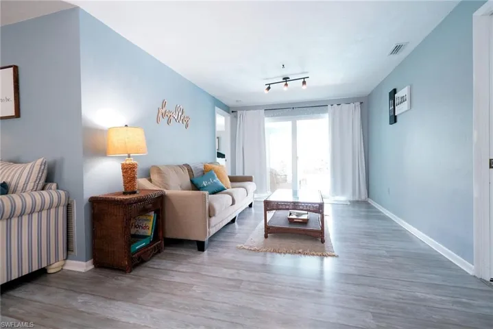 Living room with wood finished floors and rail lighting