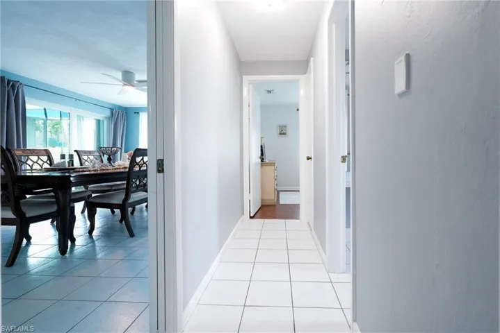 Hall featuring light tile patterned floors and baseboards