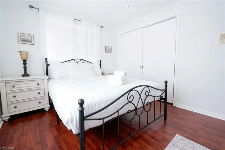 Bedroom featuring dark wood-style floors and a closet