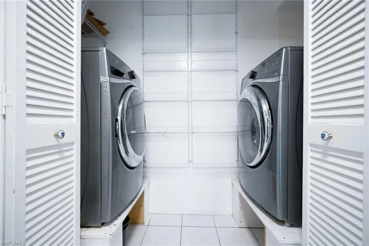 Laundry room featuring light tile patterned floors and washer / dryer