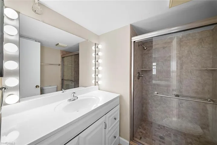 Full bathroom with vanity and a shower stall