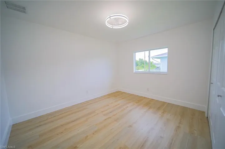 Unfurnished room featuring baseboards and light wood-type flooring