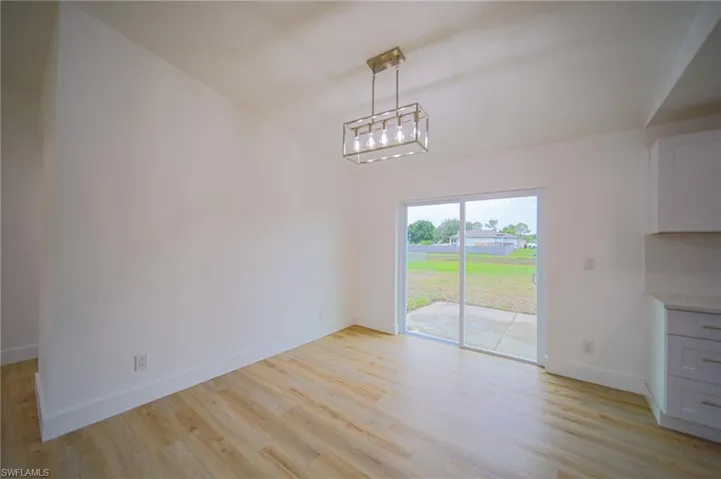 Unfurnished dining area featuring baseboards and light wood finished floors
