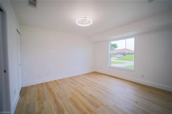 Unfurnished room featuring light wood-style floors and baseboards