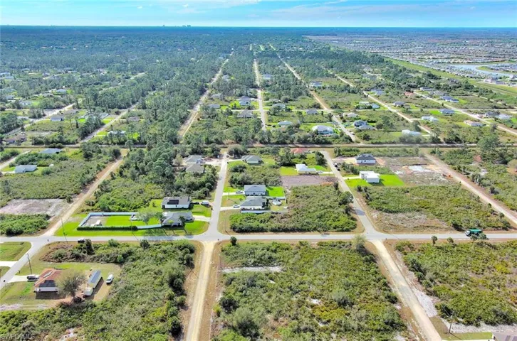 Aerial view of property and surrounding area with nearby suburban area
