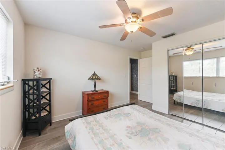 Bedroom with hardwood / wood-style flooring, ceiling fan, and a closet