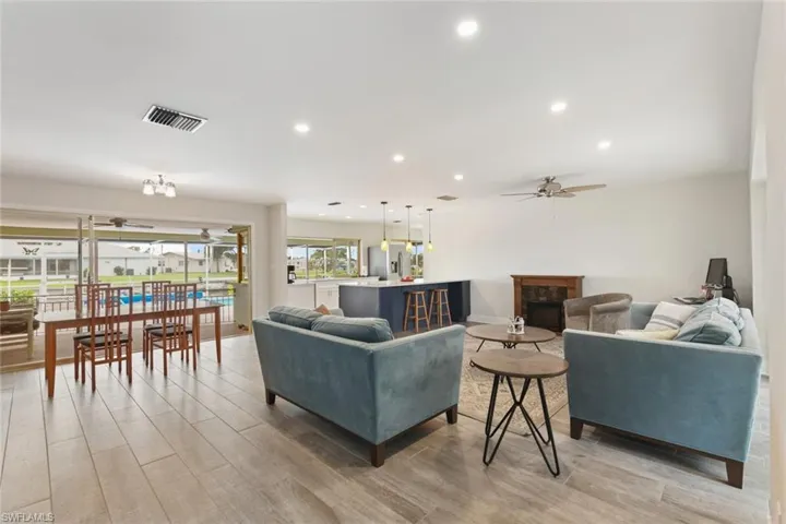 Living room featuring a fireplace, light hardwood / wood-style flooring, and ceiling fan