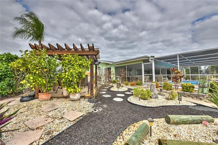 View of yard featuring a pergola, glass enclosure, and a swimming pool