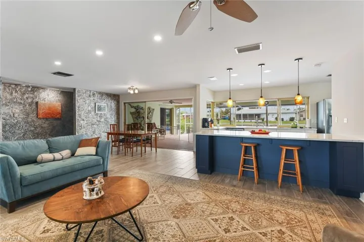 Living room with ceiling fan and light hardwood / wood-style floors