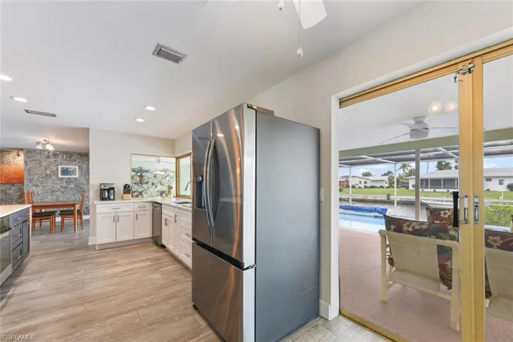 Kitchen featuring white cabinets, sink, light hardwood / wood-style flooring, ceiling fan, and appliances with stainless steel finishes