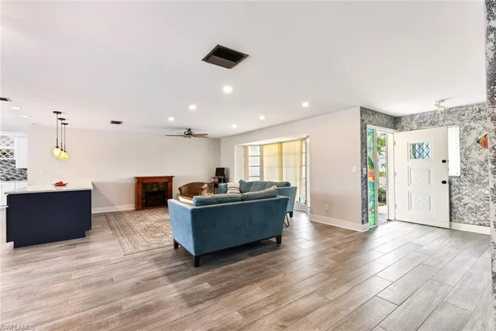 Living room with light hardwood / wood-style flooring and ceiling fan