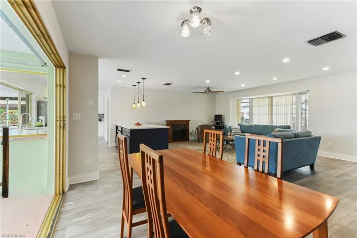 Dining area with ceiling fan and light wood-type flooring