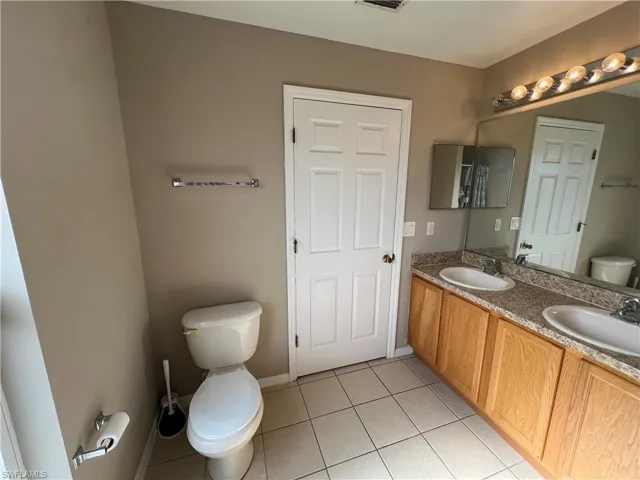 Bathroom with tile patterned floors, vanity, and toilet